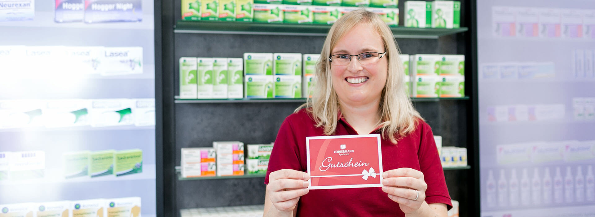 Mitarbeiterin hält Leugermann Gutschein in die Kamera